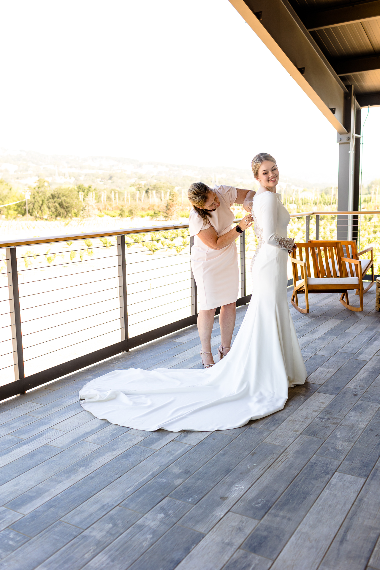 BackRoad Vines wedding - mom zipping bride into dress