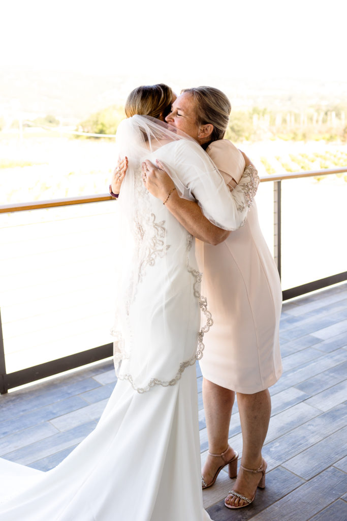 mom and bride hugging