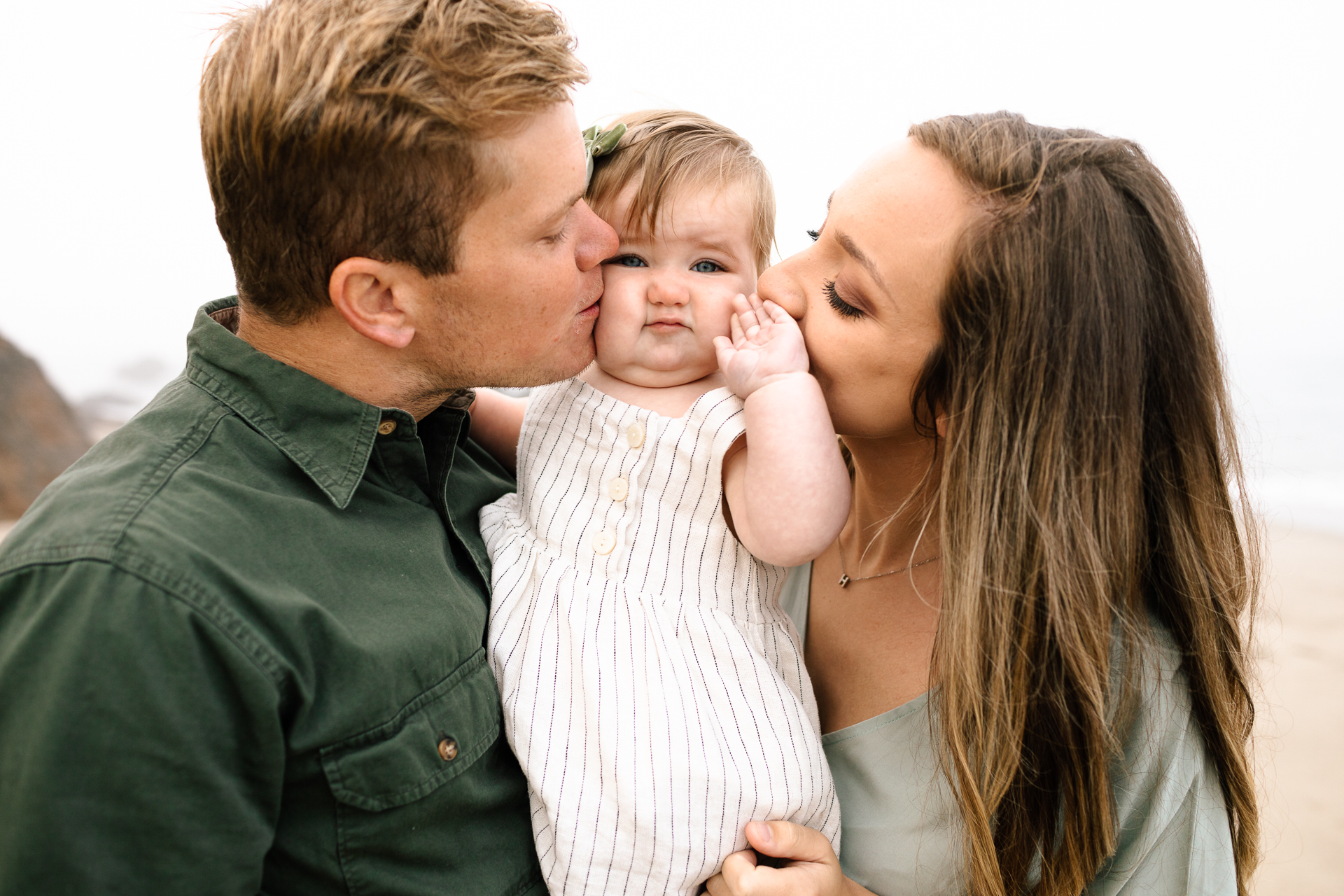 parents kissing baby's cheeks