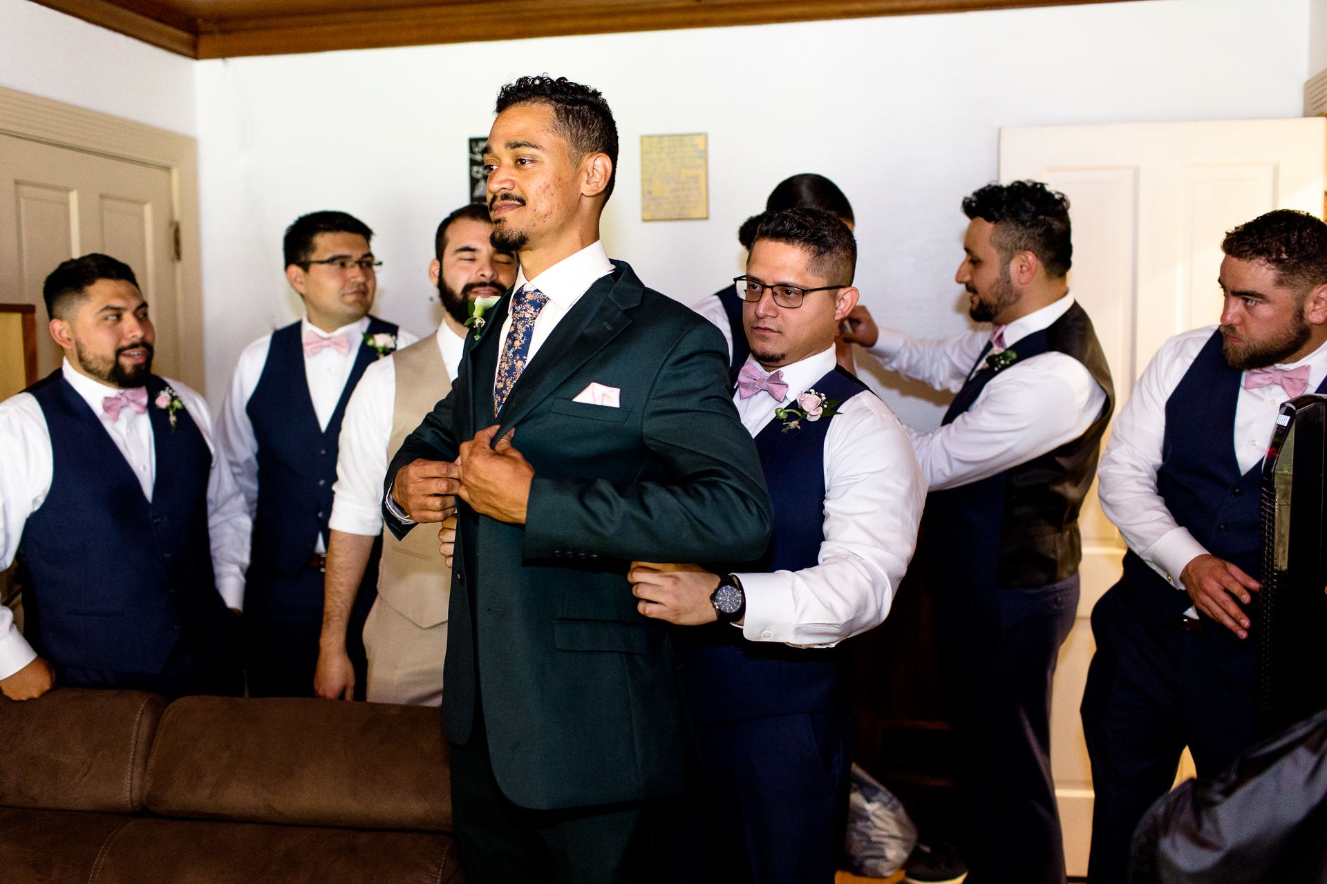 groom getting ready with his groomsmen - green suit