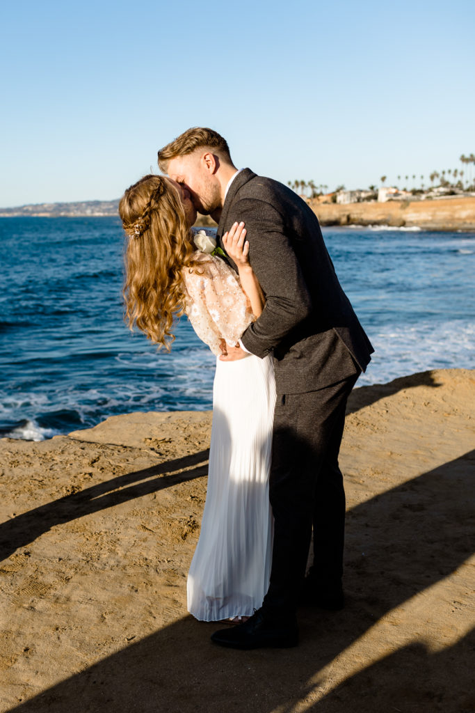 bride and groom first kiss sunset cliffs, san diego wedding