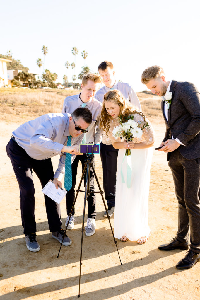 wedding party setting up a camera on a tripod - covid 19 wedding