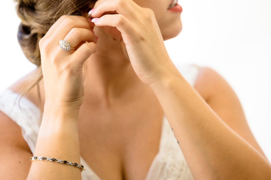 bride putting on her earrings